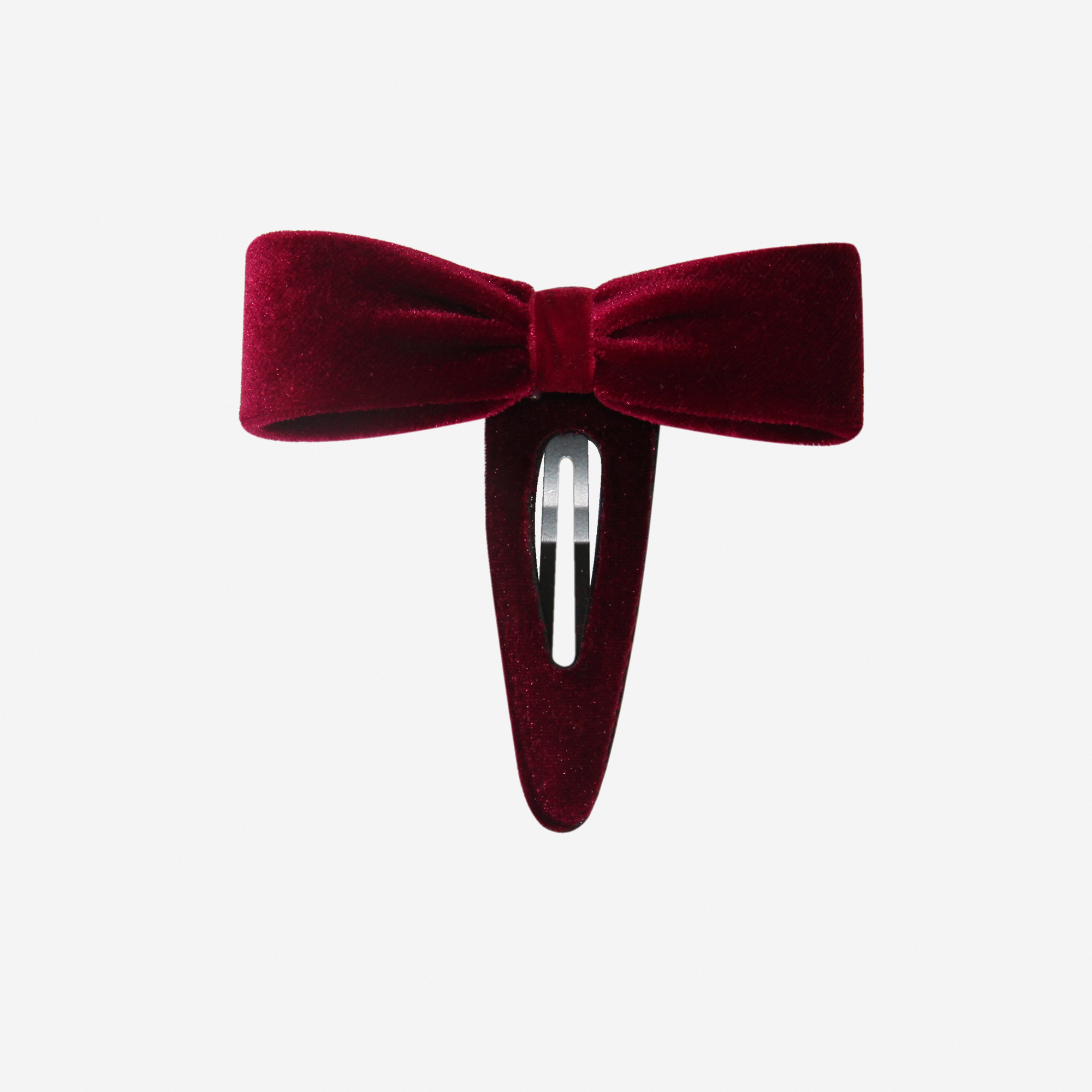 Red velvet bow hair clip on an off white background