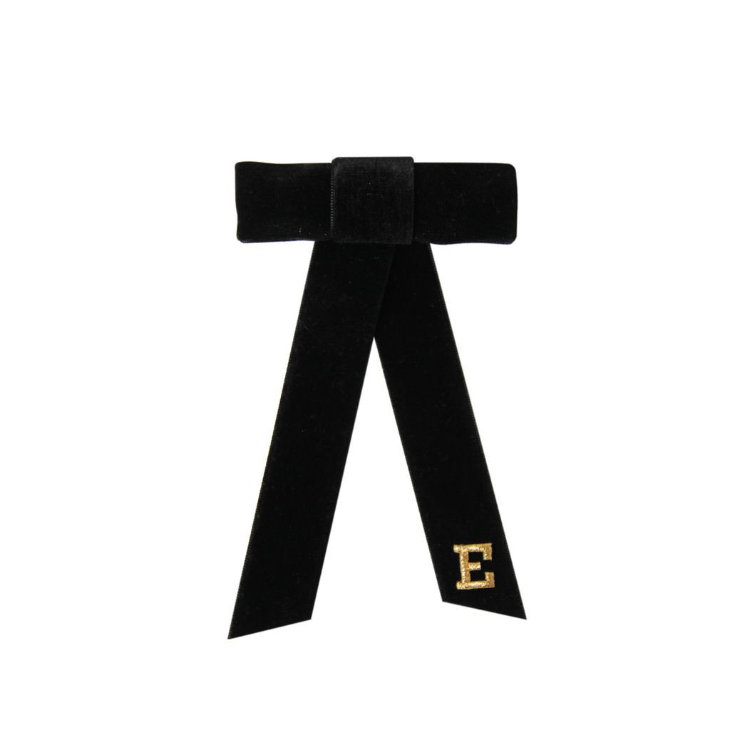 Monogrammed black velvet hair bow with gold letter 'E' on a white background
