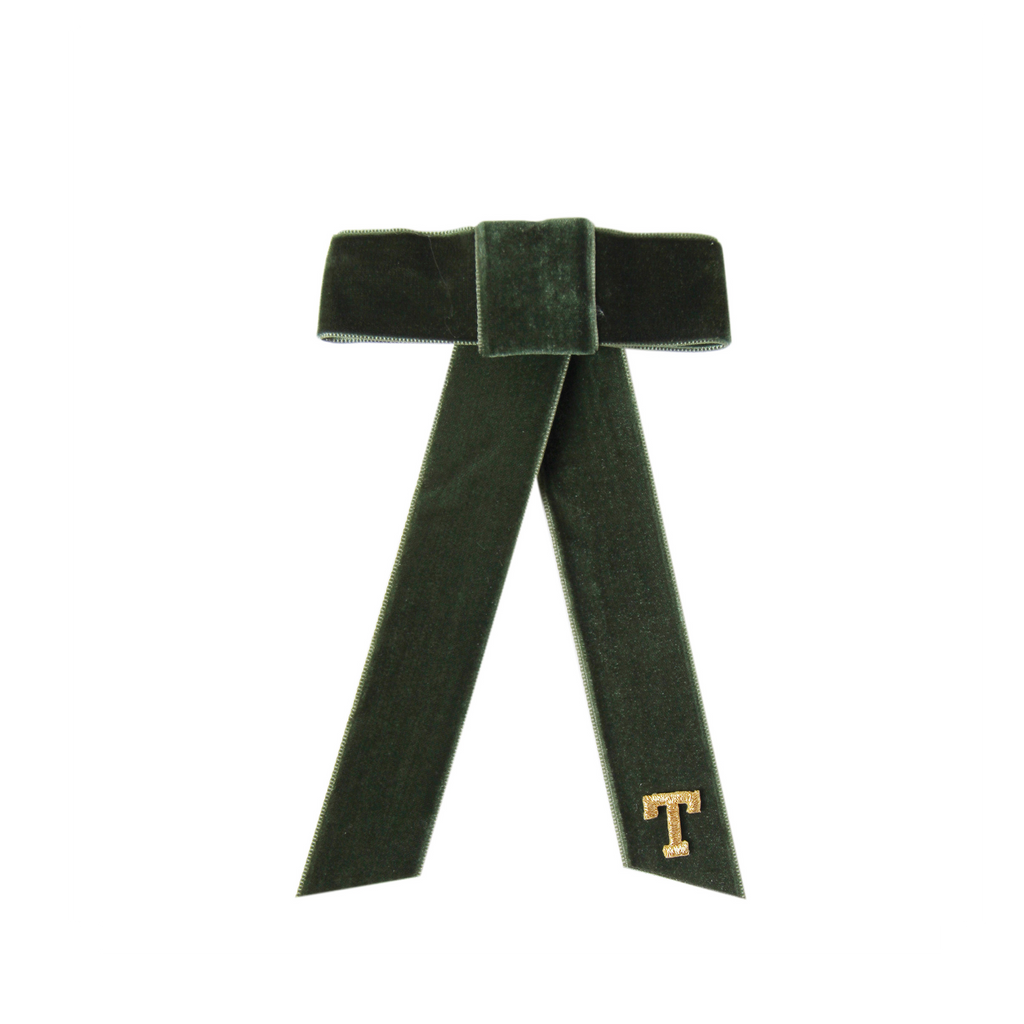 Monogrammed green velvet hair bow with a gold 'T' on a white background