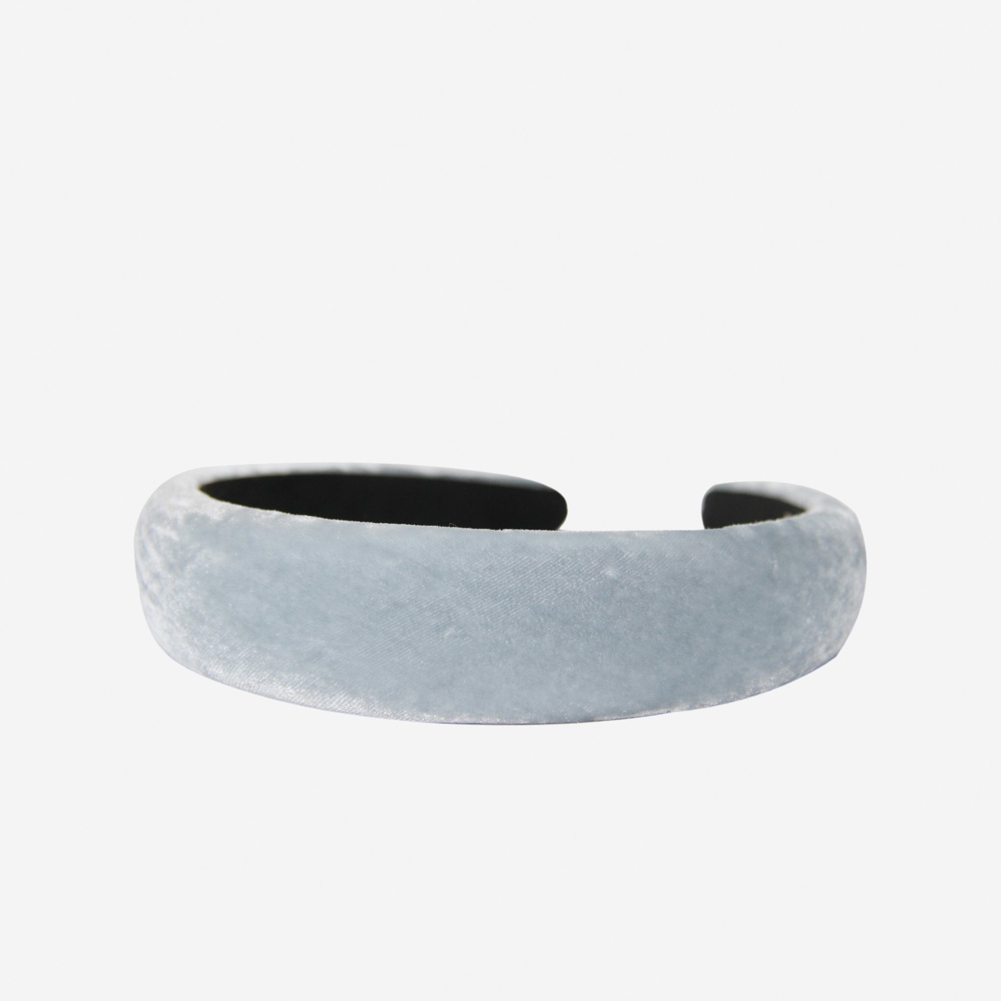 Light blue silk velvet padded headband on an off white background