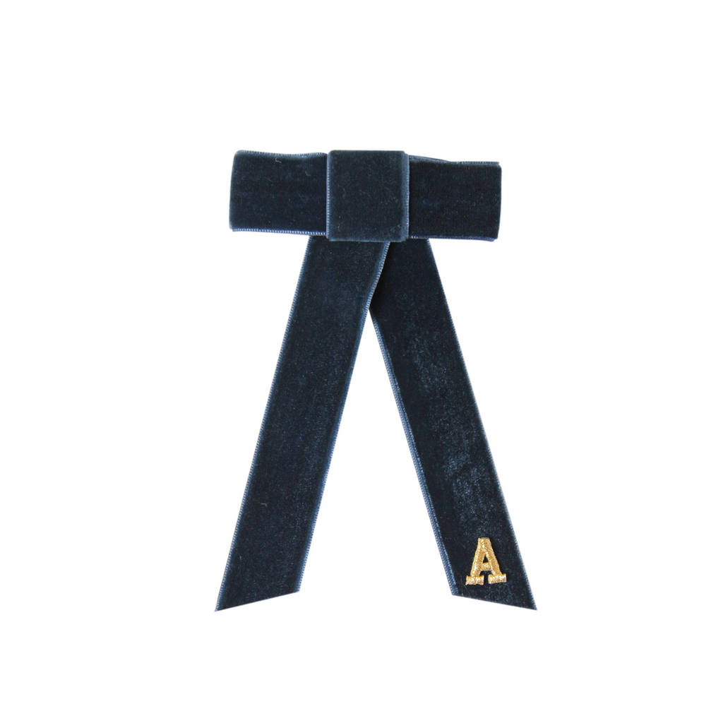 Monogrammed blue velvet hair bow with a gold letter 'A' on a white background