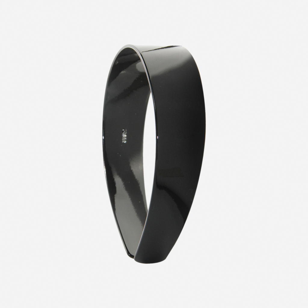 A glossy black resin hairband on a off white background