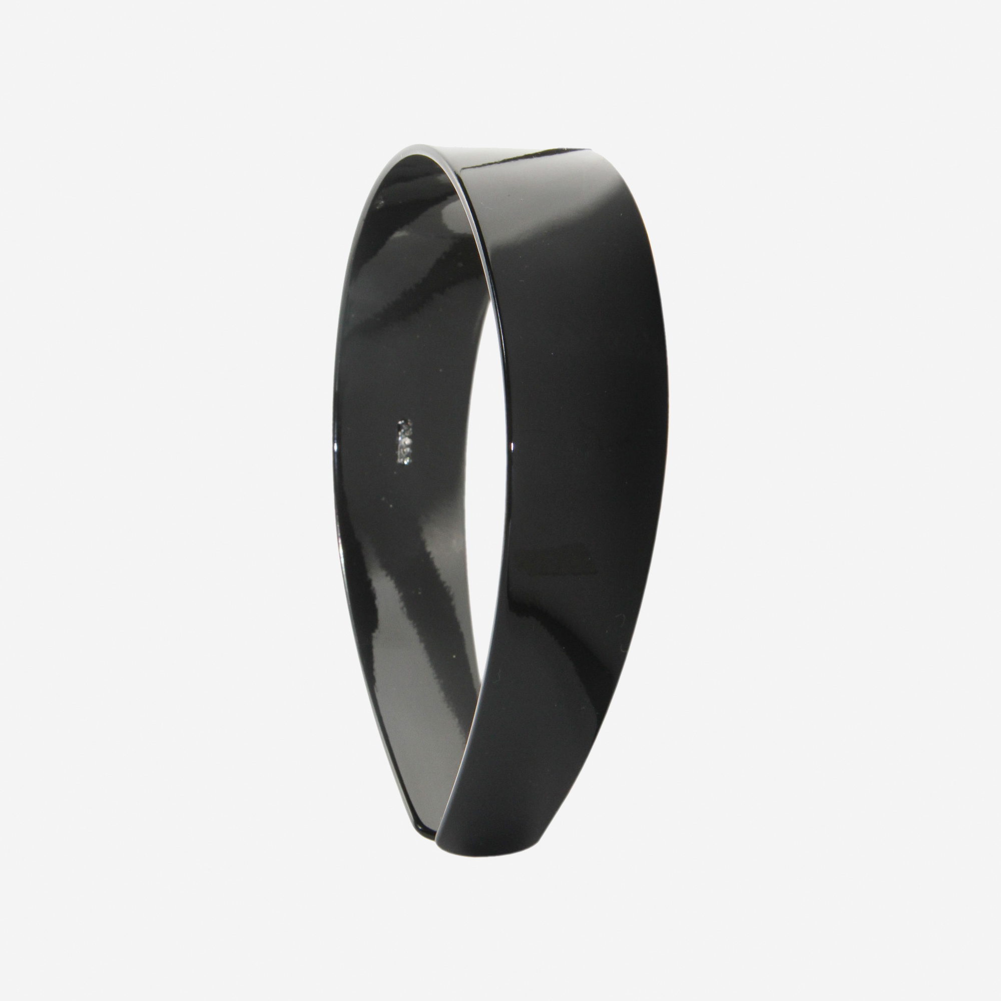 A glossy black resin hairband on a off white background