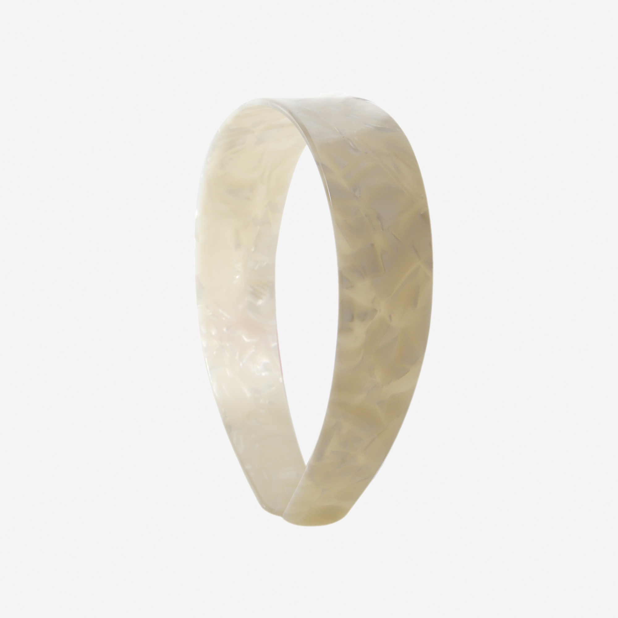 A glossy mother of pearl resin hairband on a off white background