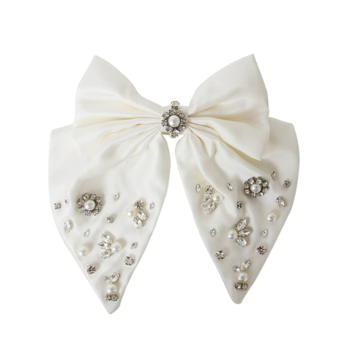 Statement white hair bow with pearl and crystal embellishments on a white background