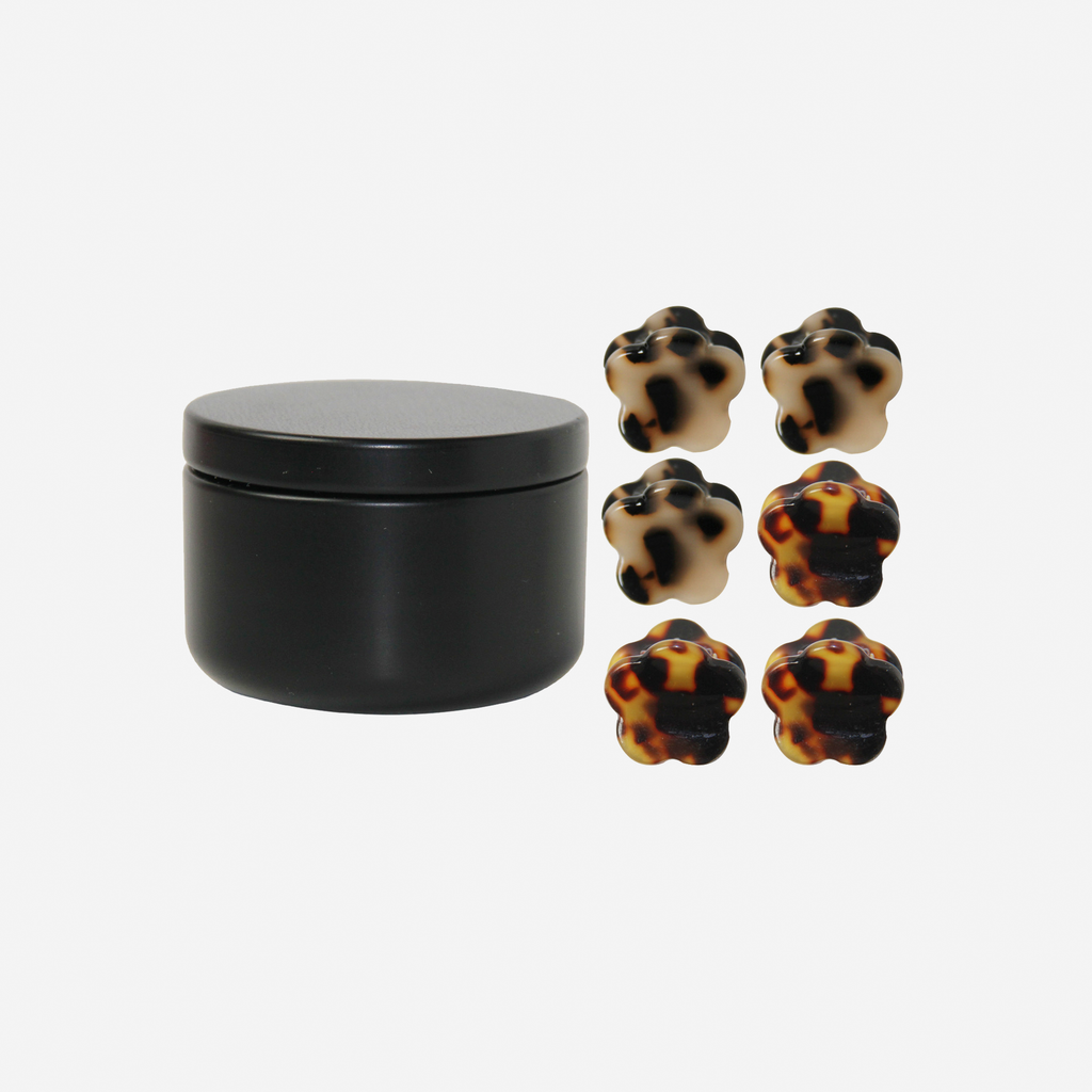 Set of 6 tortoiseshell flower shaped mini hair claws next to the black keepsake tin