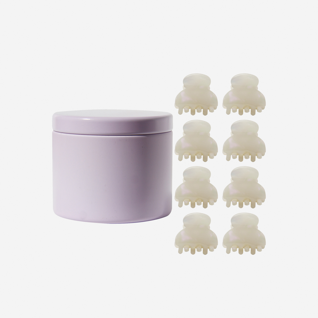 Set of 8 pearlised mini hair claws next to a lilac tin they come packaged in